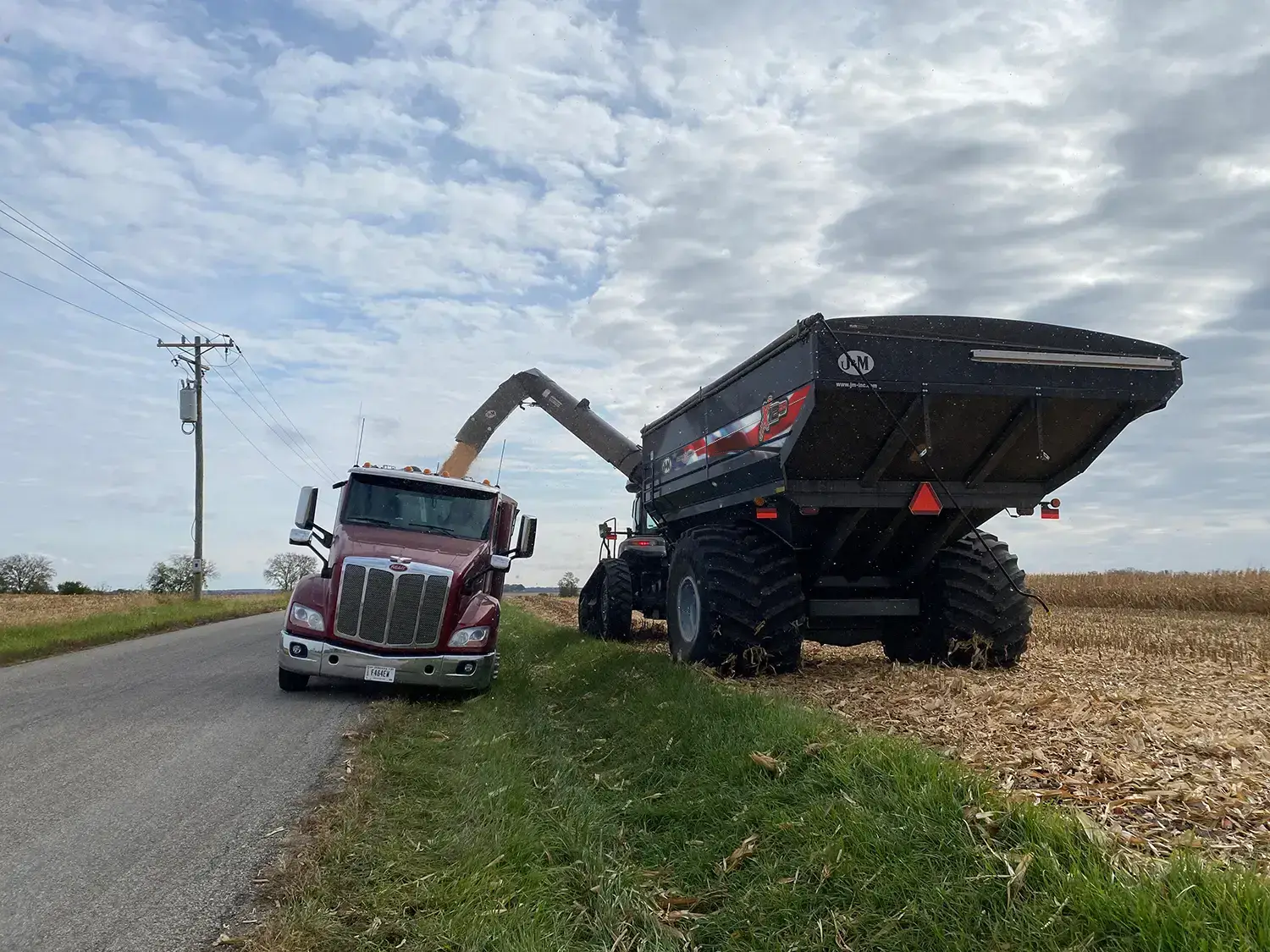Black Patriotic Farmer Grain Cart Unloading over Ditch