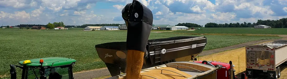 J&M 1714 grain cart unloading corn into semi-truck trailer during harvest