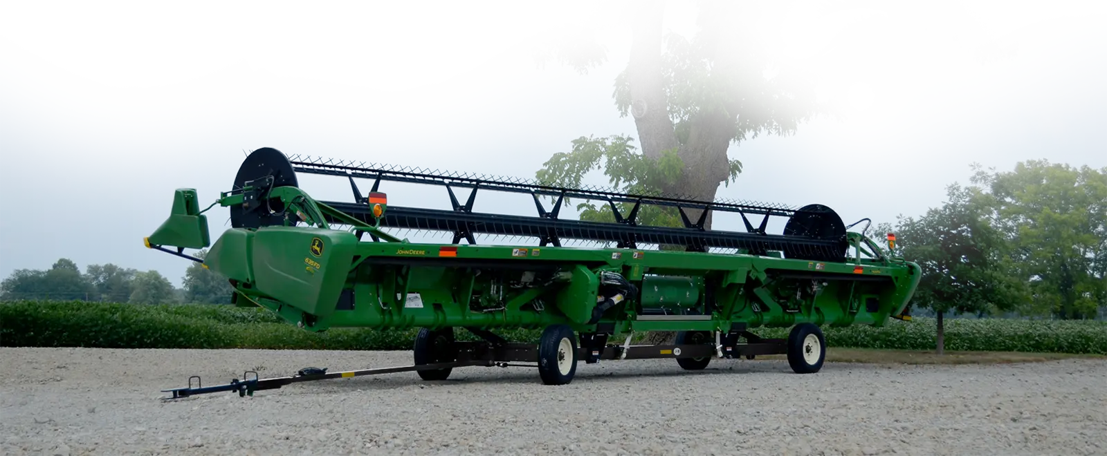 a low profile header transport that has a john deere header on it.