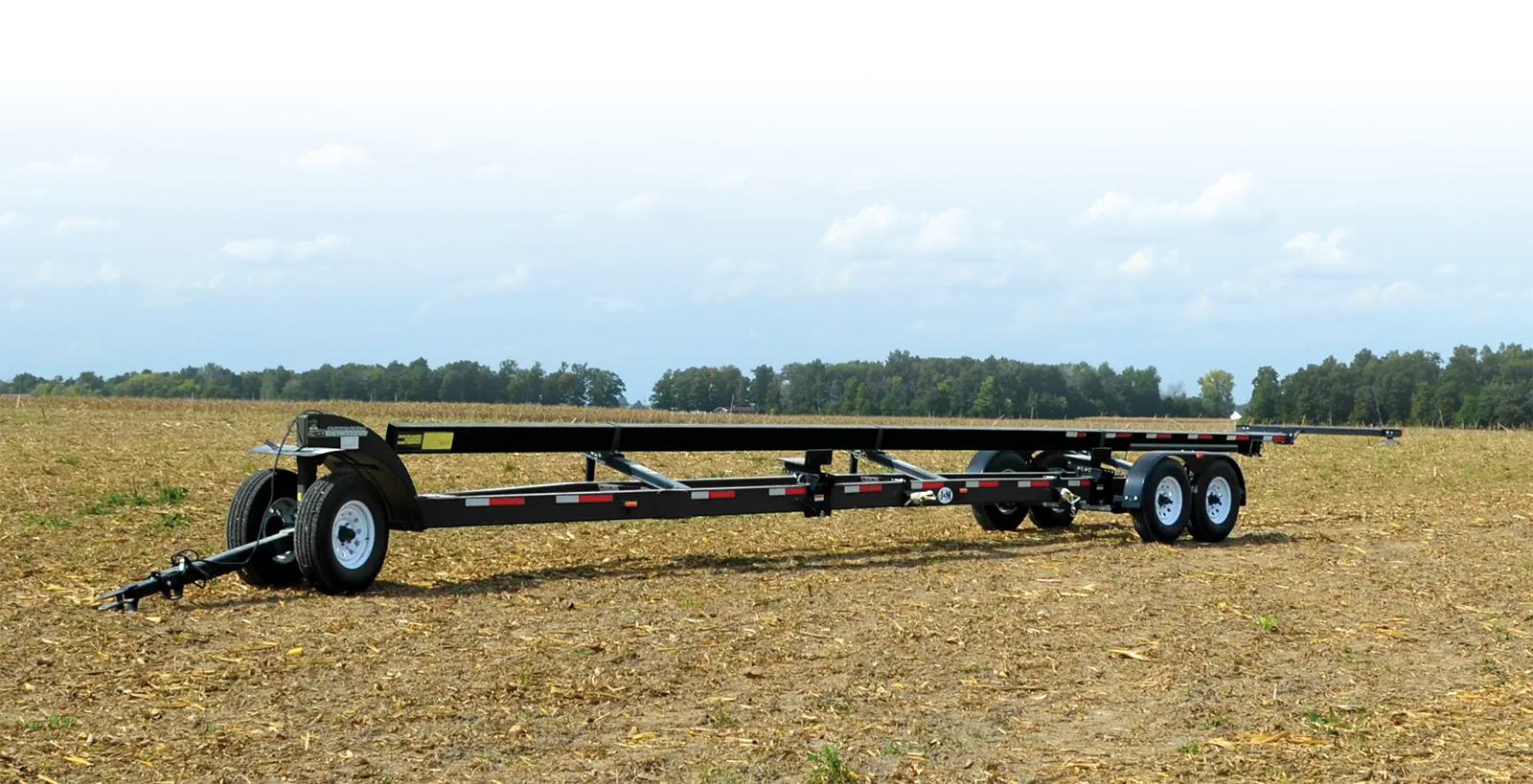 a trail blazer header transport sitting in a field.
